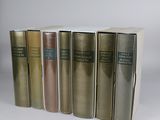 several books are lined up in a row on a white surface