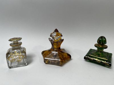 trois petites bouteilles en verre posées les unes à côté des autres sur une surface blanche