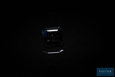 un gros plan d'un diamant noir sur une surface noire