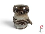 une tasse en céramique en forme de chouette, avec une anse, sur fond blanc