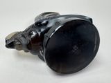 a black vase with a bear head on it on a table