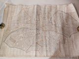 une vieille carte posée sur une table, sur laquelle sont disposés des boutons