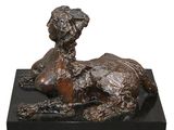 statue of a dog laying down on a black marble base