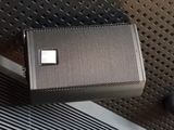 an image of a close up of a speaker on a metal surface