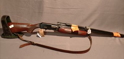 un vieux fusil avec une poignée en bois et une courroie en cuir