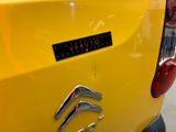 a close up of a yellow car with a sticker on it