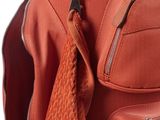 an orange golf bag with a tie hanging from it ' s side