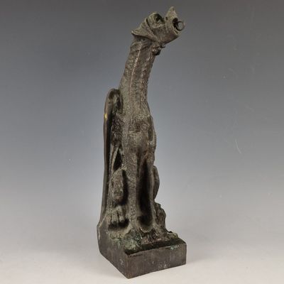a bronze statue of a dog on a pedestal with a gray background