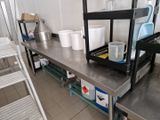 une étagère métallique sur laquelle sont posés des seaux, dans une cuisine