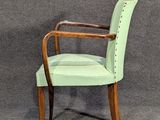 pair of green upholstered chairs against a gray background