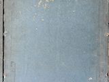 an old book with a blue cover sitting on a table