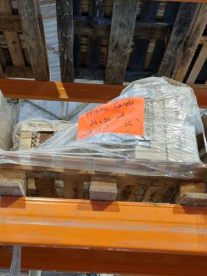 un tas de bois posé sur une palette, sur laquelle est accrochée une pancarte