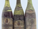 trois bouteilles de vin posées l'une à côté de l'autre sur une table