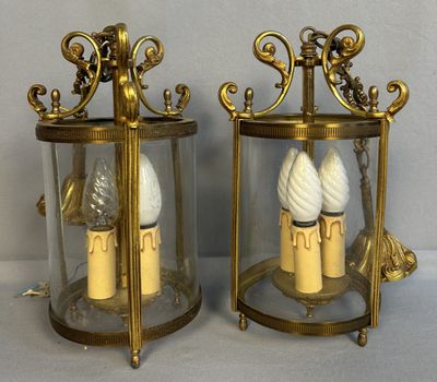 une paire de lanternes en laiton et en verre contenant des bougies