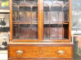 a wooden cabinet with a glass door on top of it