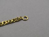 a close up of a gold chain on a gray surface