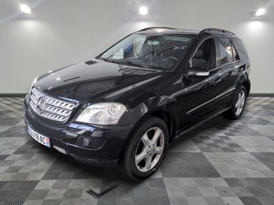 une photo d'un SUV Mercedes noir garé sur un sol à damier