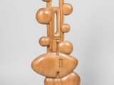 une photo d'une sculpture en bois posée sur un socle métallique