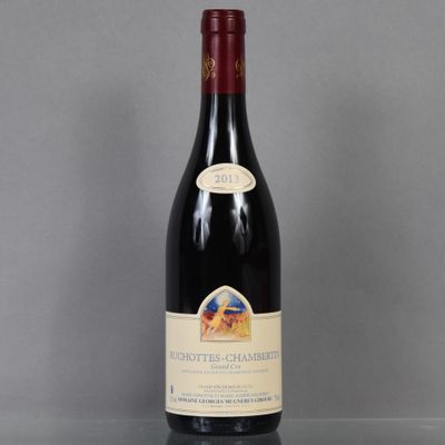 the bottle of red wine is sitting on a glass table