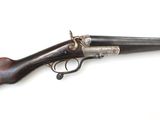 un vieux pistolet avec une poignée en bois sur une surface blanche