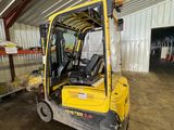 un chariot élévateur jaune garé à l'intérieur d'un bâtiment