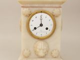 a clock that is sitting on a pedestal on a white background