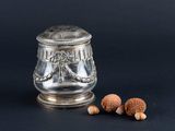 a silver plated container with nuts and nuts on a black background