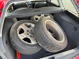 two tires in the trunk of a red car