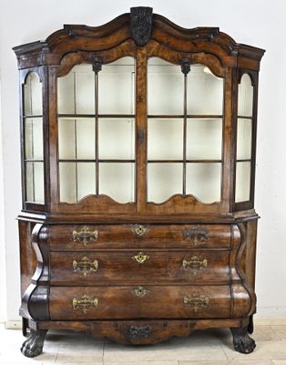 un vaisselier ancien en bois avec des portes vitrées et des tiroirs