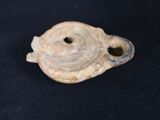 an old piece of pottery with a hole in it on a black surface
