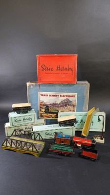 une pile de rails de train miniature et une boîte sur laquelle est accrochée une pancarte