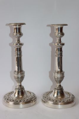 pair of silver candlesticks on a white background