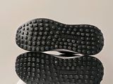 the soles of a pair of black shoes on top of a white box