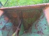 a rusted green boat sitting in the grass