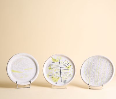 trois assiettes blanches ornées de motifs, disposées les unes à côté des autres