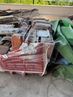 un tas de bric-à-brac par terre, près d'une clôture