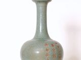 un vase vert posé sur une table blanche