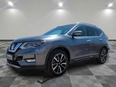 un SUV Nissan gris garé dans une pièce au sol carrelé