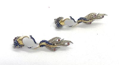 une paire de boucles d'oreilles blanches et bleues rehaussées de touches dorées sur un fond blanc