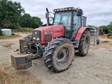 a red tractor that is parked in the dirt