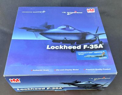 la boîte est ouverte sur la table et contient une maquette d'avion de chasse