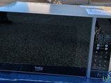 a microwave sitting on top of a box on the street