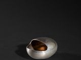 a close up of a metal object on a black surface