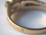 a close up of a gold ring on a white surface