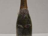 an old bottle of champagne sitting on top of a white table