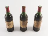 three bottles of wine sitting next to each other on a white surface