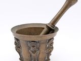 an antique mortar with a wooden pestula in it on a white background