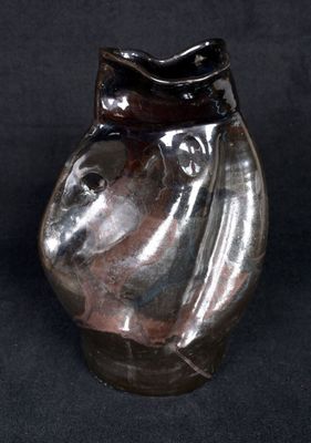 a glass vase with a horse head on it on a black background