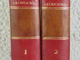 deux vieux livres reliés en cuir posés sur une table blanche