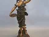 statue en bronze d'une femme tenant un oiseau sur une base en bois